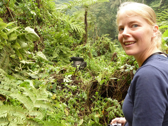 A guest enjoying a lifetime moment in company of mountain gorillas in Bwindi, while observing the 7-meter distance as one of the gorilla tracking rules & regulations