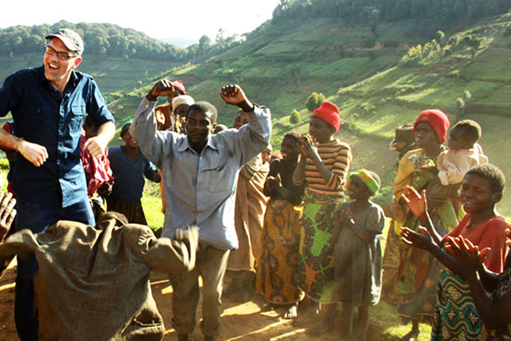 A guest enjoying an entertainment moment in a rural homestead in Bwindi Impenetrable National Park